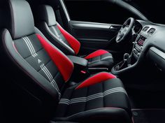 the interior of a car with red and black seats