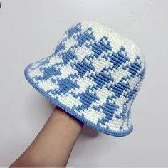 a knitted blue and white hat on someone's hand, with the pattern