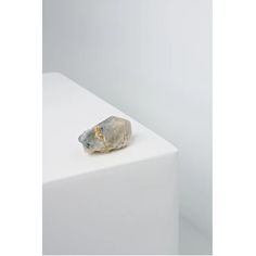 a rock sitting on top of a white block