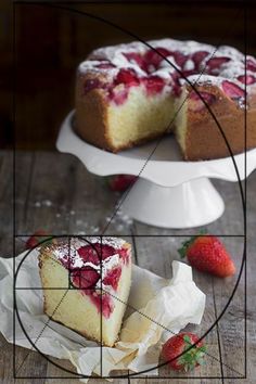 a piece of cake sitting on top of a wooden table next to a strawberry pie