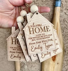 someone holding up some wooden tags with words on them and a baseball bat in the background