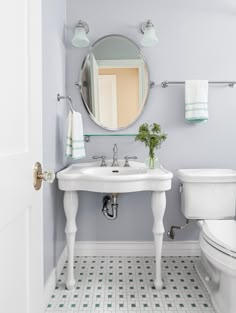 a white sink sitting under a bathroom mirror