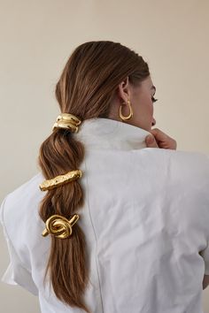 Introducing the reinvention of our best-selling Glossy Bar Barrette: the Hammered Bar Barrette. Crafted with an elevated and textured hammered finish, this modern and timeless hair accessory offers a luxurious and sophisticated touch to any look. Perfect for everyday wear, it makes an effortless statement with its classic silhouette and exquisite detail. Hair In A Ponytail, Geometric Arch, Hair Loop, A Ponytail, Elastic Hair Ties, Hair Rings, Metallic Hair, Gold Hair, Scrunchie Hairstyles