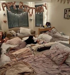 a woman laying on top of a bed in a bedroom next to a birthday banner