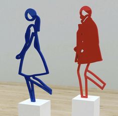 three different colored figures standing on white pedestals