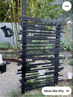 an outdoor sculpture made out of wooden slats in the middle of a gravel area