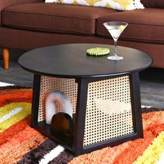 a brown couch sitting next to a table on top of a rug in front of a coffee table