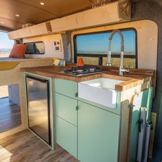 an rv kitchen with sink, stove and refrigerator