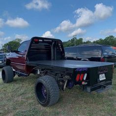 the truck is parked on the grass near other vehicles