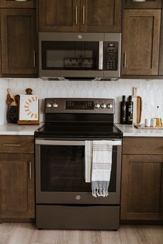 a kitchen with brown cabinets and stainless steel stove top oven in the middle of it