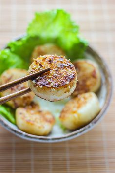 some food is in a bowl with chopsticks sticking out of it and broccoli on the side