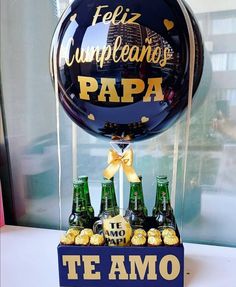 a bunch of bottles that are sitting on a table in front of a balloon with the words, feliz cumpleanos de papa