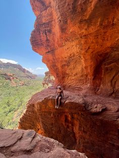 a man sitting on the edge of a cliff