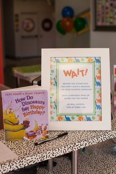 there is a sign that says how do dinosaurs birthdays? and some books on the table