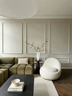 a living room filled with furniture and a large white vase