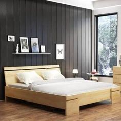 a bed with white sheets and pillows in a room next to a large window that has wood paneling on the walls