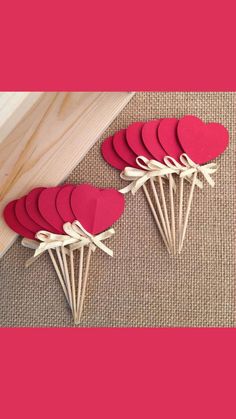 red heart shaped paper picks sitting on top of a table