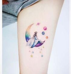 a woman's arm with a tattoo on it that has a dragon flying over the moon