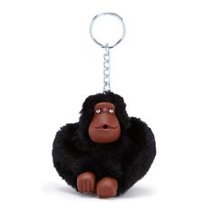 a brown gorilla keychain sitting on top of a white floor next to a chain