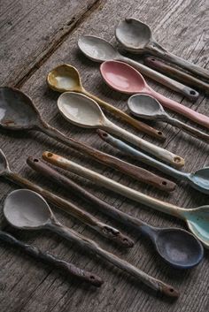 old spoons are lined up on a wooden table