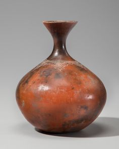 a brown vase sitting on top of a table