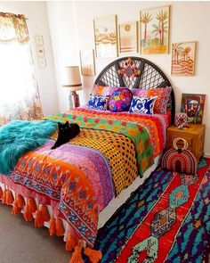 a bed with colorful blankets and pillows on it