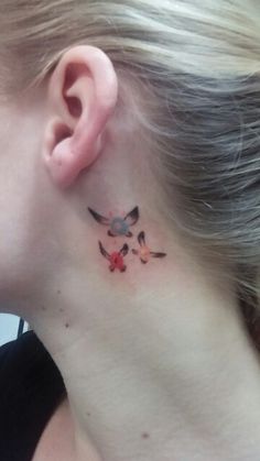 a woman with a small tattoo on her neck and behind her ear is a bird