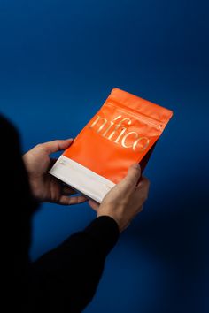 a person holding an orange bag with the word disco on it in front of a blue background