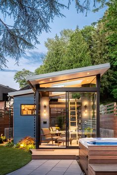 a small backyard with a hot tub and patio furniture in the back yard at dusk