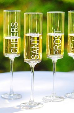 three champagne flutes filled with liquid sitting on top of a table