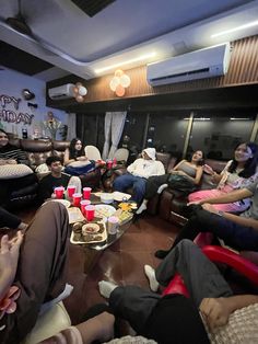 a group of people sitting on couches in a living room next to each other