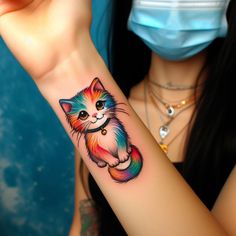 a woman wearing a face mask and holding up her arm with a colorful cat tattoo on it