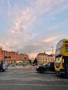 a yellow double decker bus driving down a street