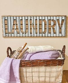 a laundry basket with towels in it next to a sign that says laundry on the wall