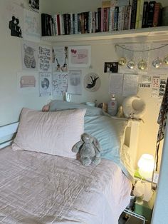 a bedroom with a bed, bookshelf and stuffed animals on the wall above it