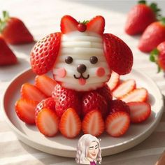 a plate topped with strawberries and a small dog figurine