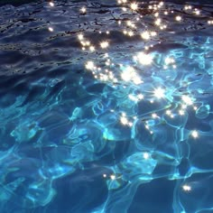 the sun shines brightly on the water in this pool with clear blue water and small white bubbles