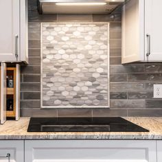 a stove top oven sitting inside of a kitchen next to white cabinets and counter tops