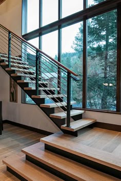 there is a stair case in the middle of this room with wood floors and glass windows