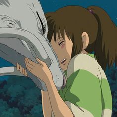 a woman kissing a white animal on the nose