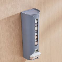 a toothbrush holder is attached to the side of a wall with several small white objects in it