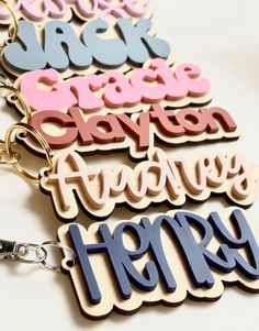 four key chains with different types of letters on them, all in different colors and shapes