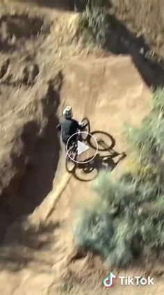 a man riding a bike down a dirt hill