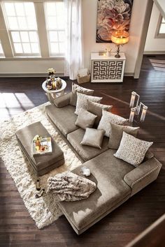 a living room filled with furniture on top of a hard wood floor covered in lots of pillows