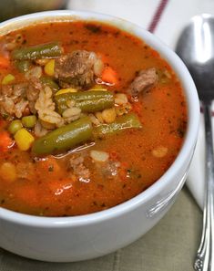 a white bowl filled with meat and vegetable soup