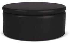 a black round ottoman sitting on top of a white floor