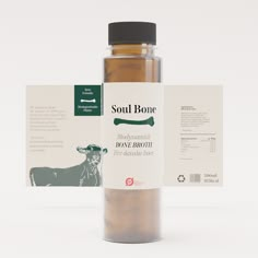 a bottle of bone broth sitting next to a label on a white background with an image of a cow