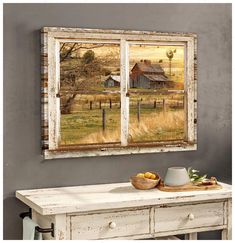 an old window with a farm scene on it and a bowl of fruit in the foreground