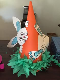 a paper hat with an image of a bunny on it and some other decorations around it