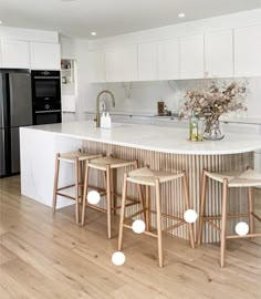 a kitchen island with stools in front of it